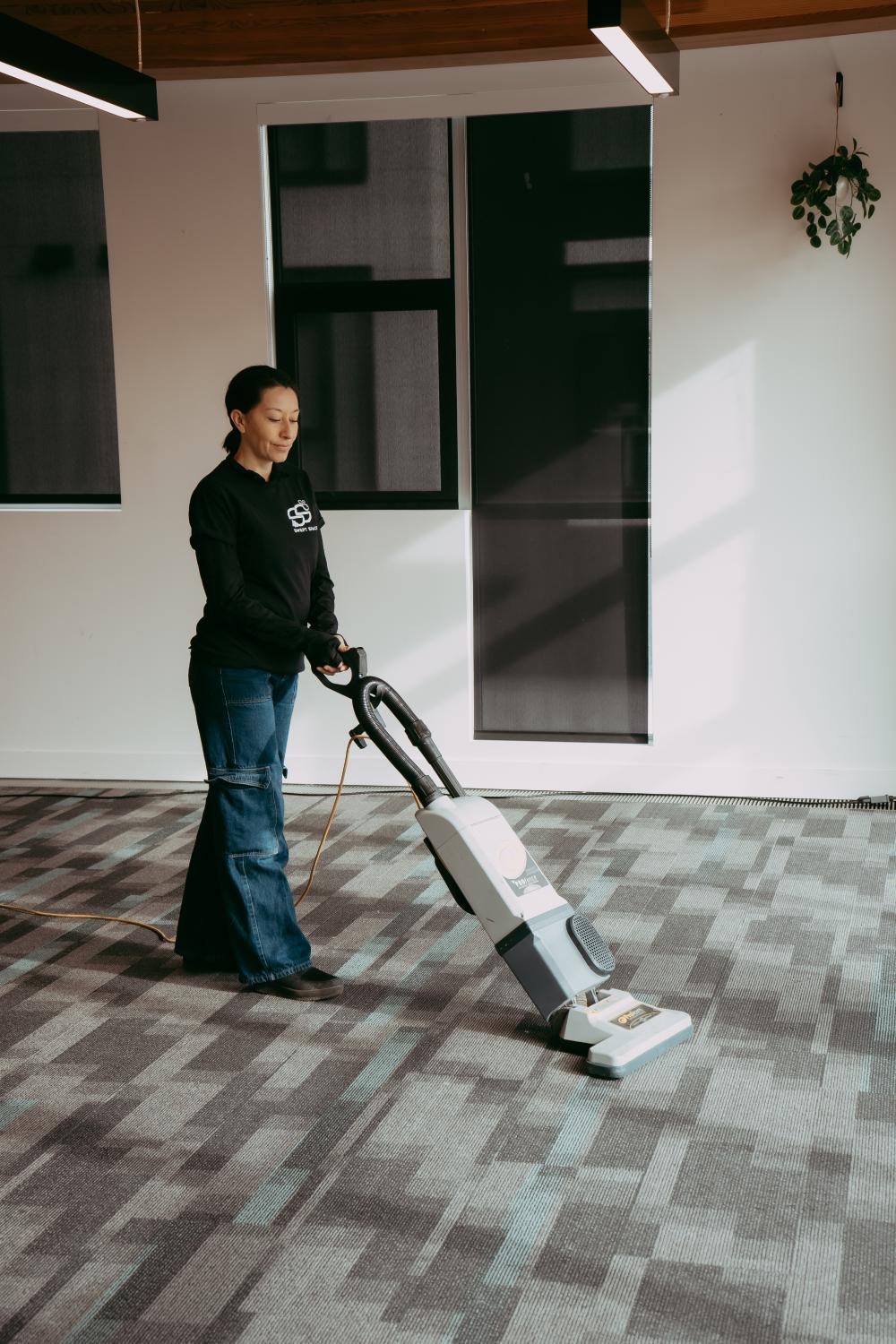  Woman vacuuming office floor